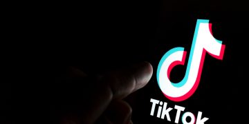 Tiktok,App,Logo,On,Screen,And,A,Finger,Pointing,At